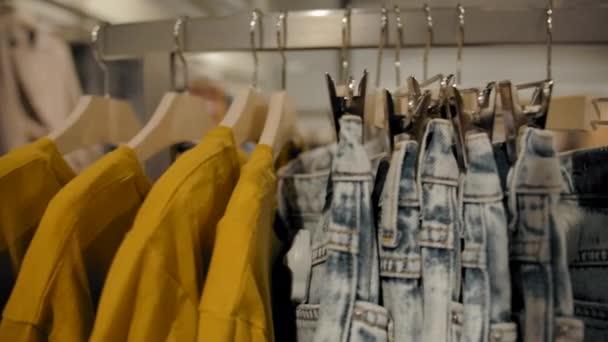 Bastidores con ropa en tienda — Vídeos de Stock