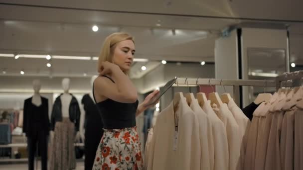 Mujer joven usando la tableta en la tienda — Vídeo de stock