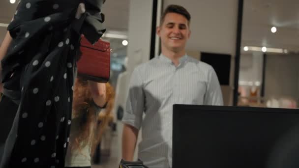 Ευτυχισμένο ζευγάρι που δίνει ρούχα στον πωλητή — Αρχείο Βίντεο