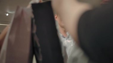 Genç adam ve kadın tanınmayan mağaza müdüründen kağıt torba alıyor.