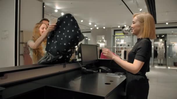 Milující pár dává látku pokladní v módním obchodě — Stock video