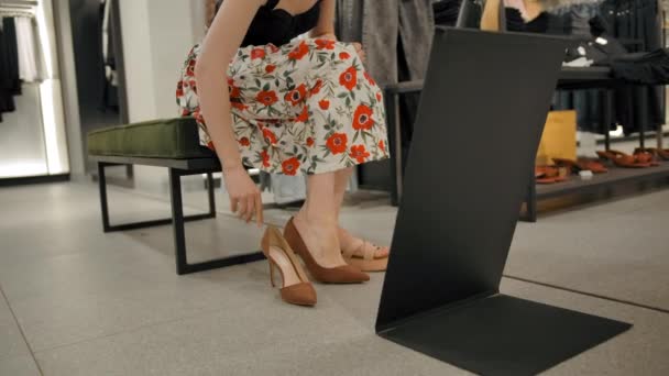 Het meisje past schoenen in de kledingwinkel van het winkelcentrum — Stockvideo