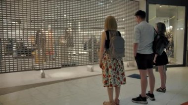 Üç müşteri mağazanın açılmasını bekliyor. Geliyor..