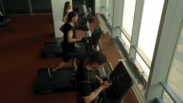 Crane derribó a gente deportiva, corriendo en cintas de correr en un gimnasio — Vídeos de Stock