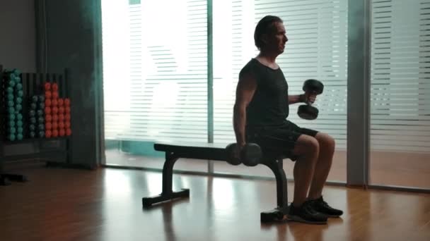 Mature homme soulevant de gros haltères pour pomper ses biceps — Video