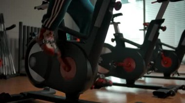 Spor salonunda bisiklete binen aktif bir sporcu.