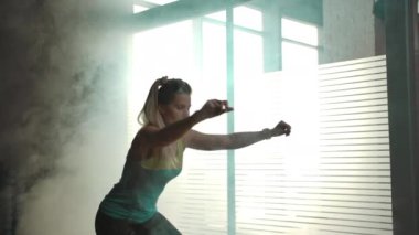 Kız spor salonundaki yarım kürede çömeliyor.