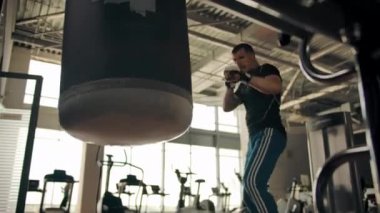 Boxer Gölge Boksu. Boksör yumruk torbasını tekmeliyor ve tekmeliyor.