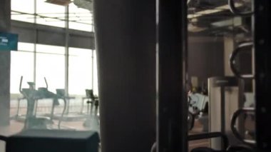 Agresif sporcu boksör spor salonunda kum torbasına vuruyor.