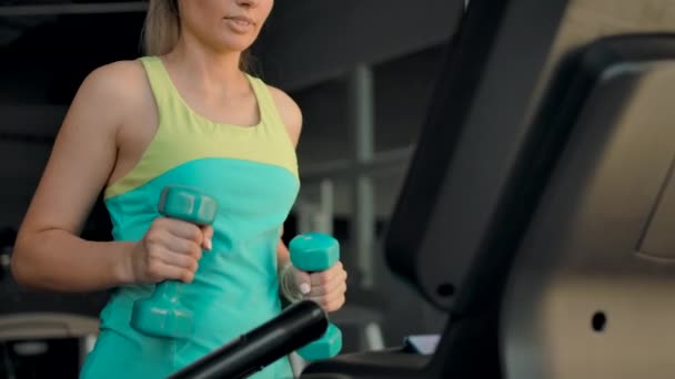 Caucasian woman on a treadmill walking and with two dumbbells. — Stock Footage Caucasian woman on a treadmill walking and with two dumbbells. Video Clip