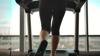 Güzel seksi kadın bacakları spor salonunda koşu bandında