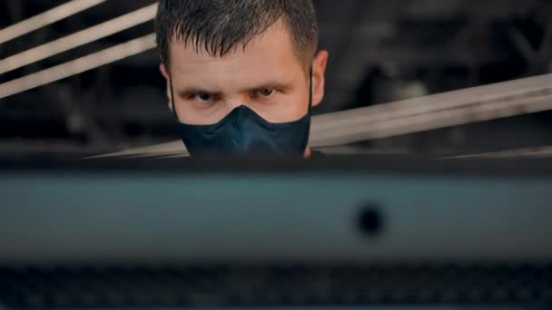 Πρόσωπο ενός μέτριου δυνατού άνδρα στο διάδρομο φορώντας προστατευτική μάσκα από ιούς — Αρχείο Βίντεο