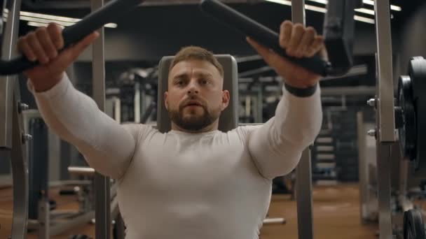 Hombre musculoso fuerte haciendo ejercicios de bíceps en la máquina de ejercicios — Vídeos de Stock