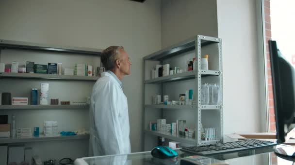 Caucásico hombre comprueba la medicina y mira a la cámara en la farmacia. — Vídeo de stock