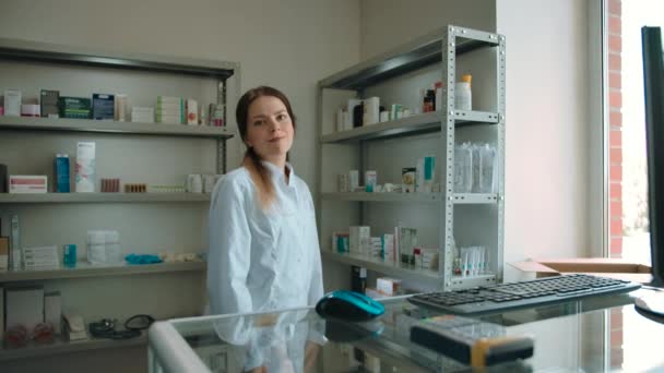 La chica farmacéutica comprobó las mercancías y está lista para servir a los clientes. — Vídeo de stock
