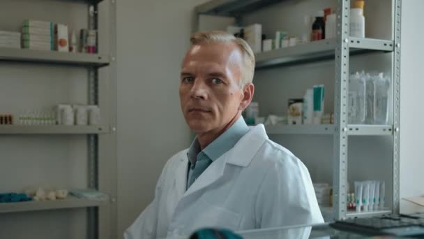 Retrato de un farmacéutico masculino rotando en una silla y sonriendo a la cámara — Vídeo de stock