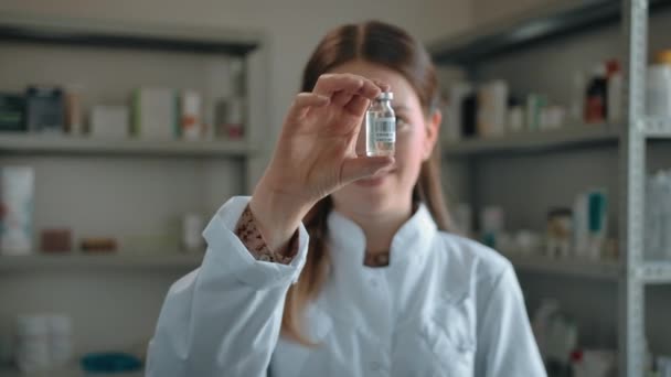 Woman pharmacist shows to the camera the covid-19 coronavirus vaccine — Stock Video