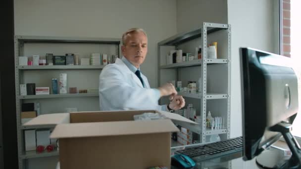 Entrega del desembalaje del farmacéutico de la acción cubierta del interior de la farmacia — Vídeo de stock