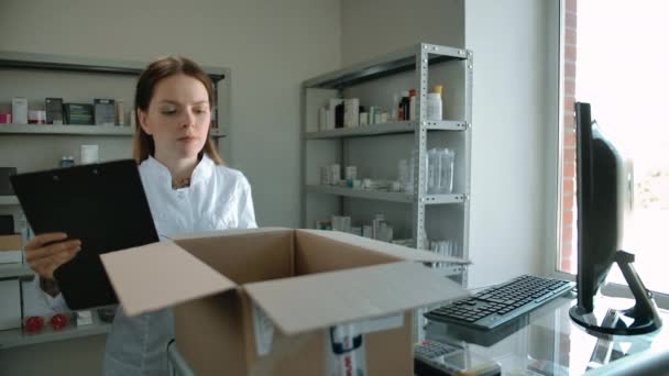 Attraktiv kaukasisk kvinna packa upp leverans med läkemedel på apotek — Stockvideo