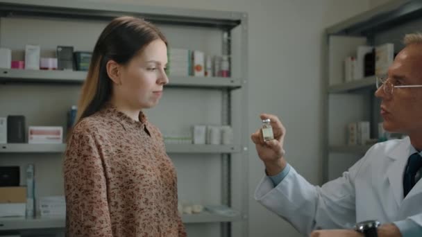 약국의 여성 고객에게 COVID-19 백신을 제공하는 약사의 근접 사진. — 비디오