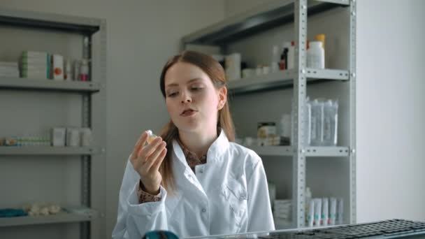 Женщина-фармацевт рекламирует коронавирусную вакцину и дает ее клиенту — стоковое видео