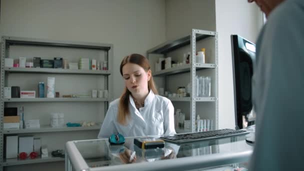 Mujer farmacéutica preparando material de medicina para el comprador con tarjeta de crédito. — Vídeo de stock