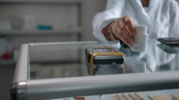 Onherkenbaar persoon voert het te betalen bedrag per creditcard in de apotheek in — Stockvideo