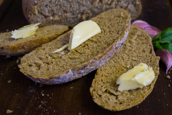 Plasterki świeżego chleba z plasterkami masła i ząbki czosnku. — Zdjęcie stockowe