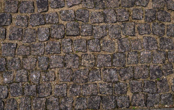 Tekstura chodnika z granitowych kamieni brukowych. — Zdjęcie stockowe