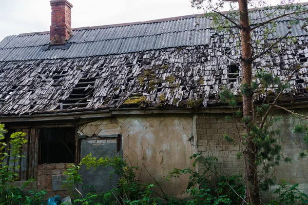 Abandonado, derrumbándose casa en el campo. Agujeros en el techo y paredes . —  Fotos de Stock