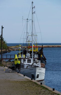 Eski tekneler ve uzun tekneler bir şaka ile eski bir iskele. Baltık Denizi Riga Körfezi.