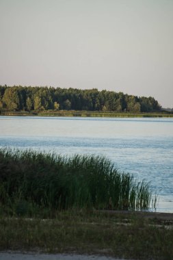 Gün batımında gölde sessiz su genişliği.