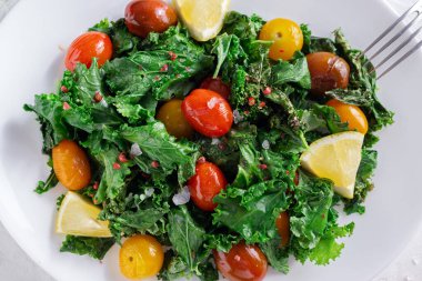 Roasted cabbage with kale and cherry tomatoes and lemon slices.