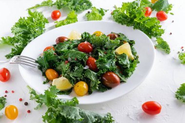 Roasted cabbage with kale and cherry tomatoes and lemon slices.