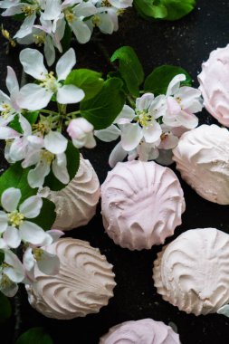 Masada leziz pembe ve beyaz şekerlemeler ve çiçek açan elma ağacı dalıyla birlikte. Tatlılar