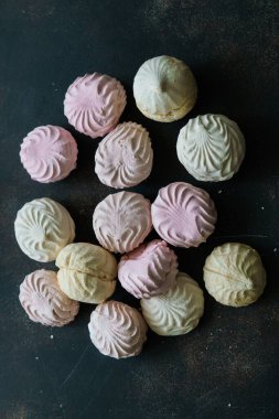 Lezzetli beyaz-pembe şekerlemeler ve bir elma ağacının çiçek açan dalı.