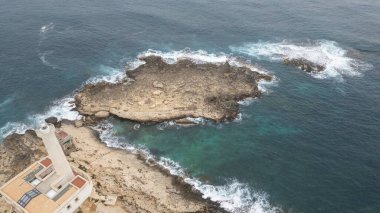 Dalgaların kayalarla buluştuğu yer Sicilya 'nın vahşi kıyı şeridi, engebeli sahili şekillendiren turkuaz deniz.