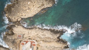 Dalgaların kayalarla buluştuğu yer Sicilya 'nın vahşi kıyı şeridi, engebeli sahili şekillendiren turkuaz deniz.