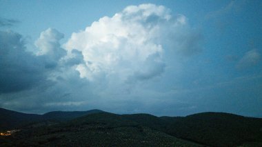 Toskana bulutları yuvarlanan yeşil tepeler üzerinde sürükleniyor.