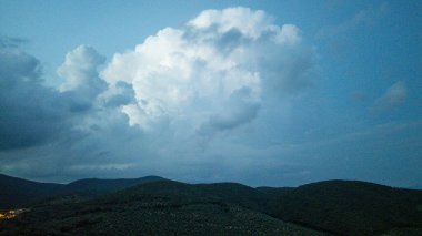 Toskana bulutları yuvarlanan yeşil tepeler üzerinde sürükleniyor.