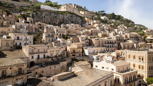 Güneşli bir barok kasabası olan Sicilya 'dan Modika tepelerden aşağı çağlayan altın evleri ve ebedi Akdeniz cazibesiyle.