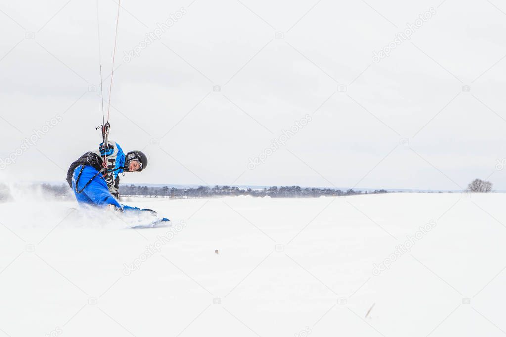 man rides a kite in winter