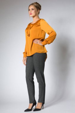 Genç model sarı bluz ve gri pantolon poz