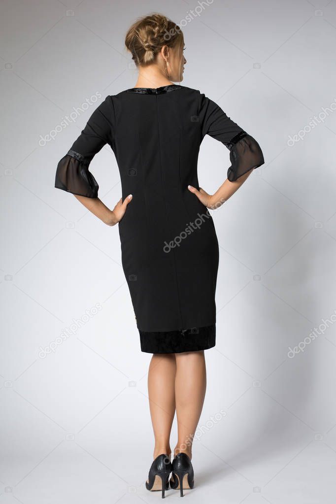 Beautiful blonde girl posing in luxury black dress