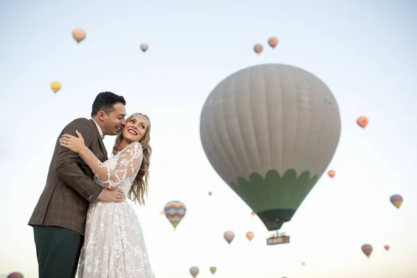 美丽的婚礼夫妇摆姿势在大自然附近的气球 — 图库照片