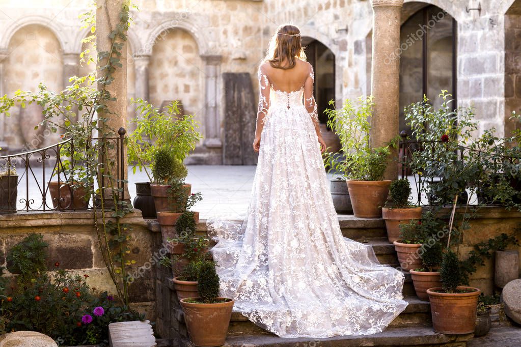 Beautiful bride posing on stairs of old building in Turkey