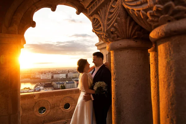 城市に日の出でポーズ美しい結婚式のカップル — ストック写真