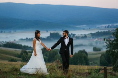 Sis tepelerde üzerine poz güzel düğün çifti