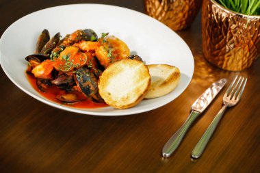 Fırında kabuklu midye patates ve ekmek ile