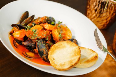 Fırında kabuklu midye patates ve ekmek ile